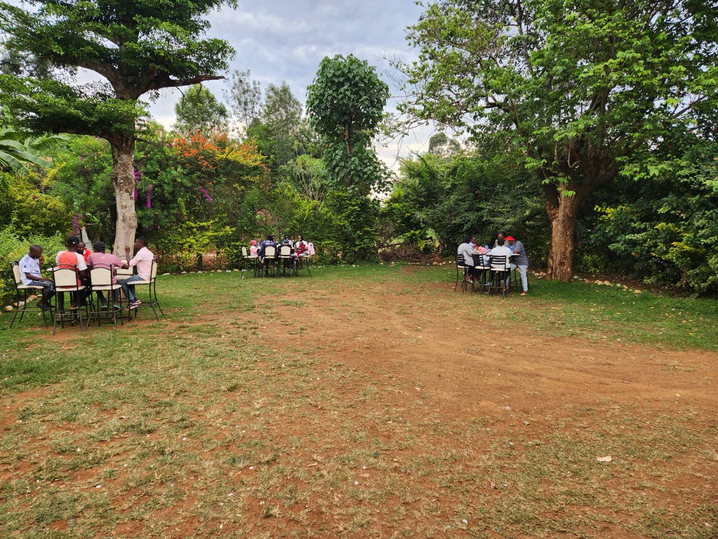 Guests seated under the trees in the Kabs Lounge yard